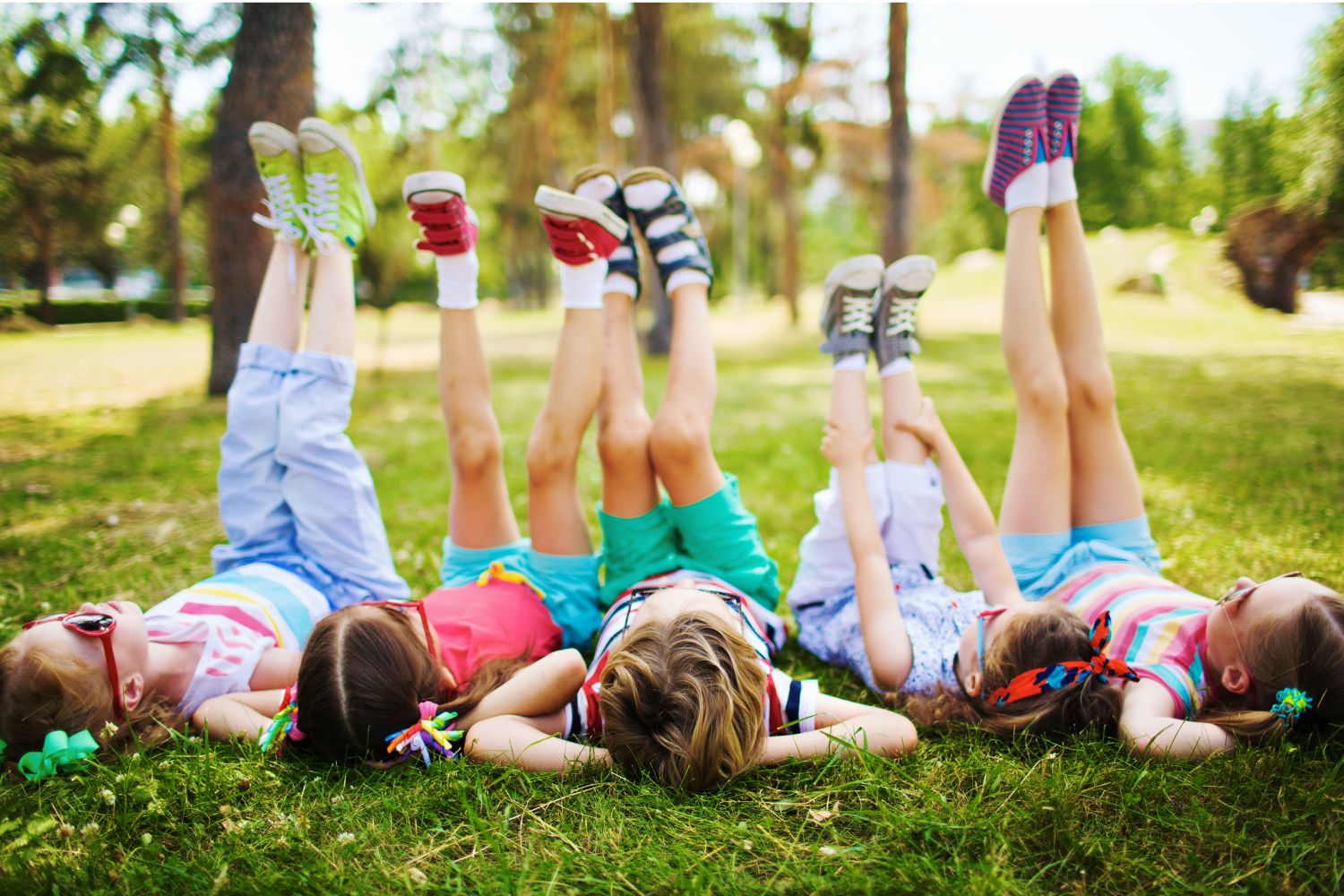 5 Kinder liegen glücklich im Gras